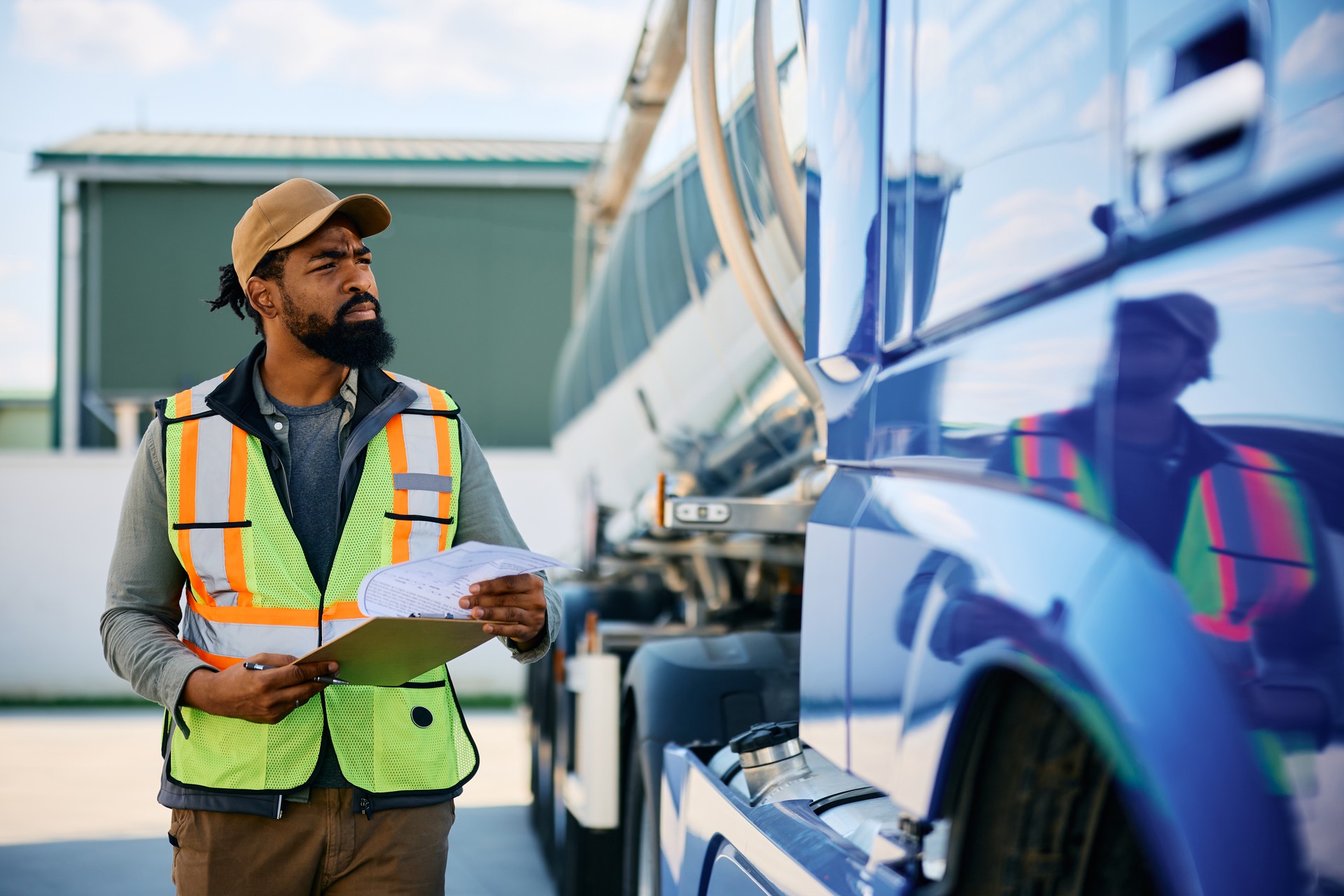 Black transportation manager while going through checklist on parking lot.